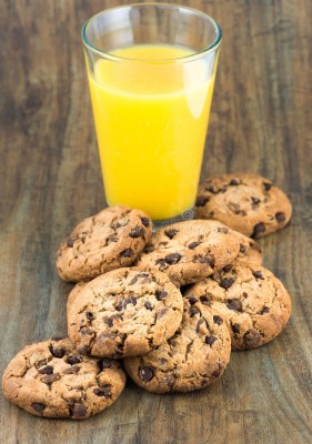 chocolate-chip-cookies-glass-orange-juice-table-32686232.jpg